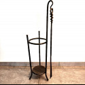 A wrought-iron umbrella stand with a shoehorn