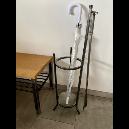 A wrought-iron umbrella stand with a forged shoehorn