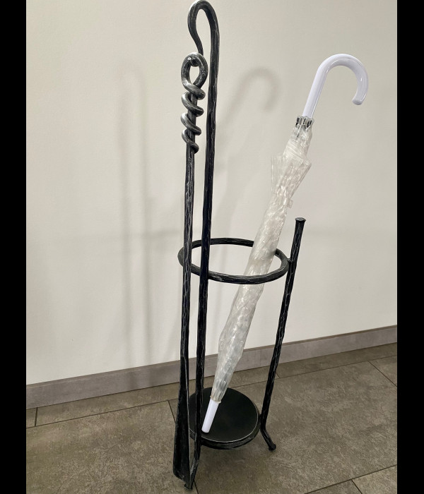 A wrought-iron umbrella stand with a shoehorn