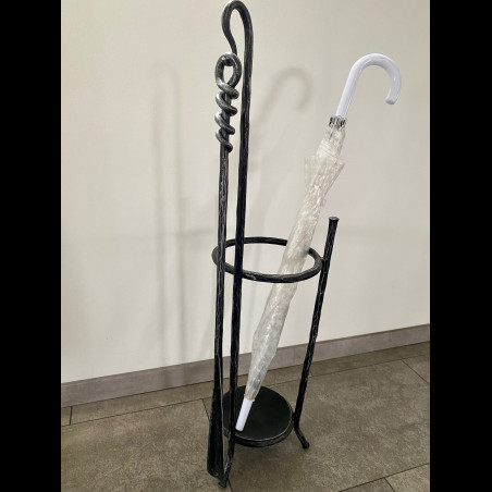 A wrought-iron umbrella stand with a shoehorn