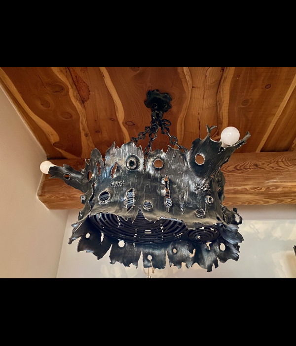 A wrought iron chandelier - an oak stump - an interior light