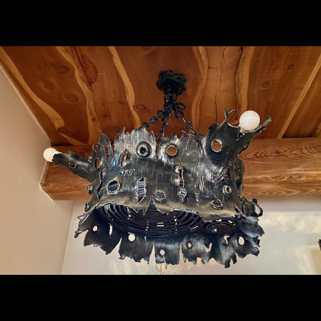 A wrought iron chandelier - an oak stump - an interior light