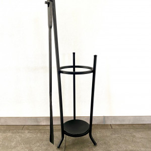 A wrought-iron umbrella stand with a forged shoehorn